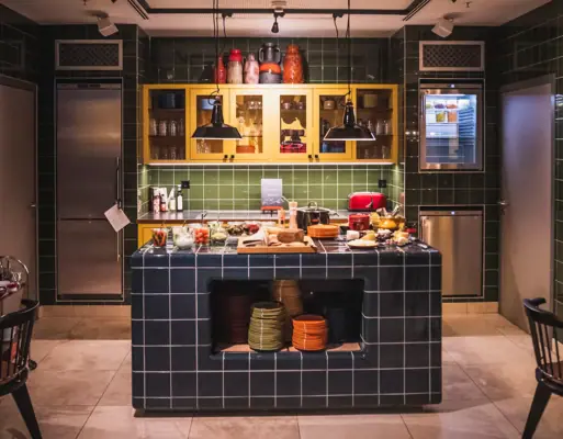 Een keuken met aanrecht en stoelen.