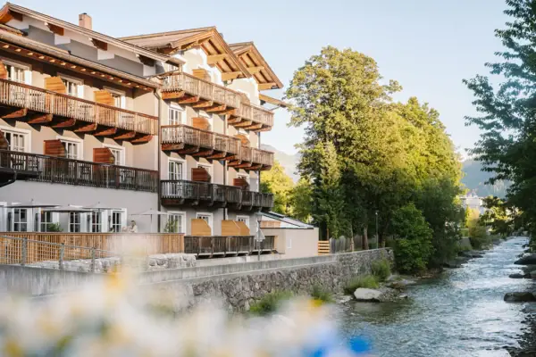 Een gebouw met balkons en een rivier op de voorgrond.