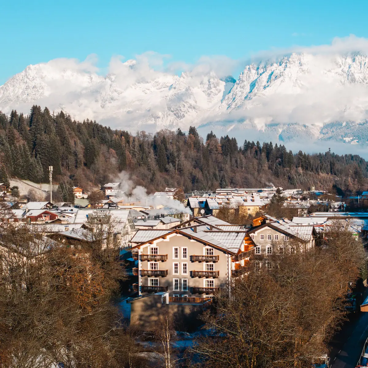 Hotel Kitzbühel De stad Kitzbühel in de winter met besneeuwde bergen op de achtergrond.