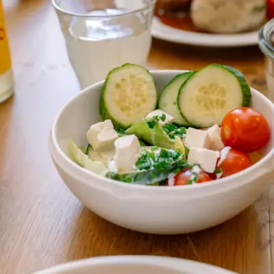 Een kom salade met komkommer en tomaten.