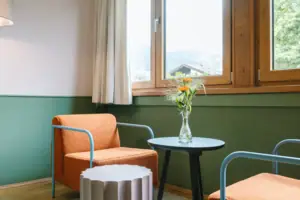 Een tafel en een stoel in een gezellige hotelkamer in het HENRI Hotel Garmisch-Partenkirchen.