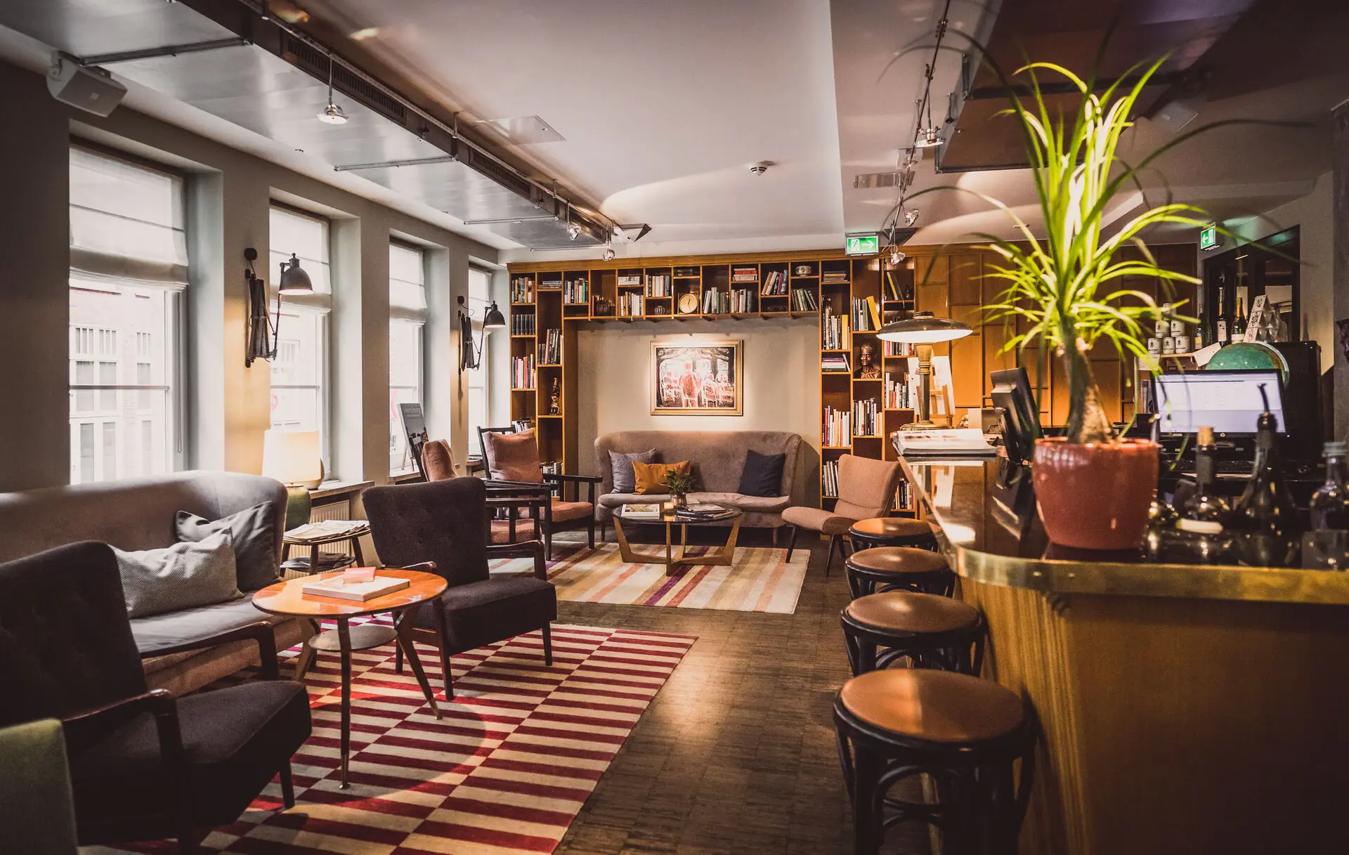 Loungehoek met bar, krukken, fauteuils en kleine tafeltjes. 