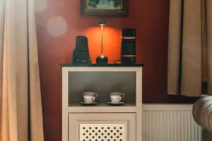 Salon Haus Kaiser HENRI Kitzbühel Een kamerbar in het HENRI Kitzbühel met kopjes en een lamp erop.