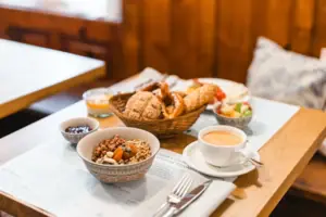 Een ontbijttafel met eten en een kopje koffie.