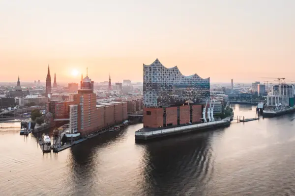 Stadsgezicht van Hamburg met wateroppervlak en gebouwen bij zonsondergang.