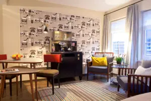 Een kamer met een koffiezetapparaat en stoelen.