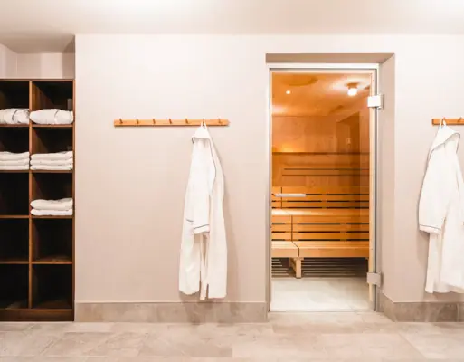 Een kamer met sauna en handdoekenrek.