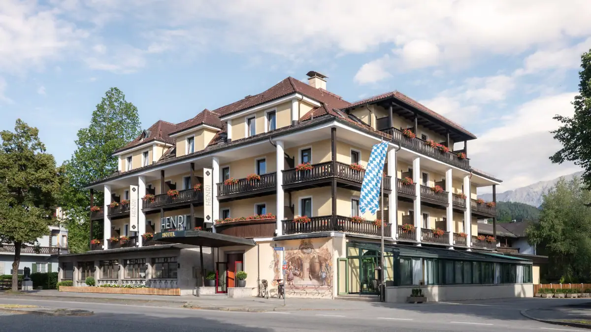 HENRI Garmisch-Partenkirchen Een gebouw met veel balkons tegen een heldere lucht.