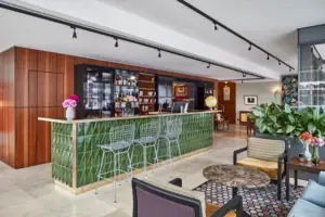 HENRI Düsseldorf Bar met groene tegels en stoelen.