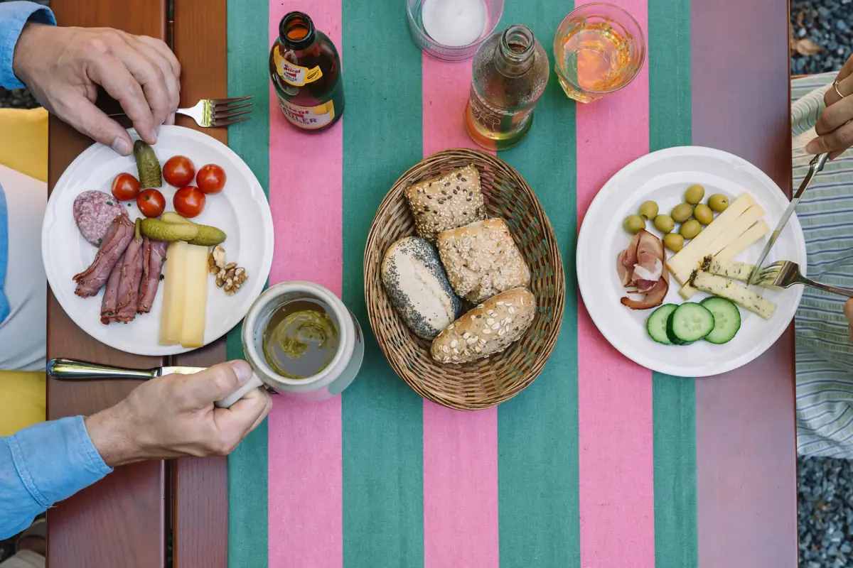 Persoon met een beker en een bord eten.