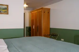 Entree van Salon Plus in HENRI Garmisch-Partenkirchen Hotelkamer met bed en kledingkast