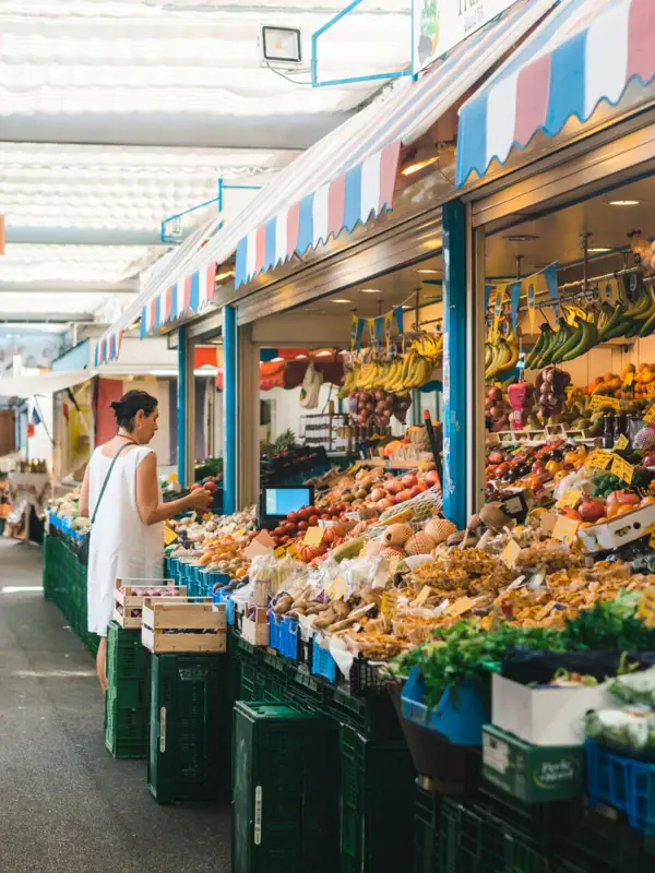 Vrouw voor een fruitkraam op een markt.