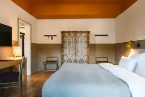 Hotelkamer in het HENRI Hotel Garmisch-Partenkirchen met een bed en een houten kledingkast.