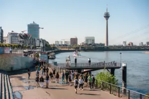 Düsseldorf Een groep mensen loopt over een pad bij een meer.