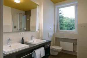 HENRI GAP-salon met balkon Badkamer met raam en wastafel
