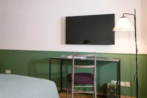 Tv en bureau in HENRI Garmisch-Partenkirchen De tv aan de muur in de hotelkamer