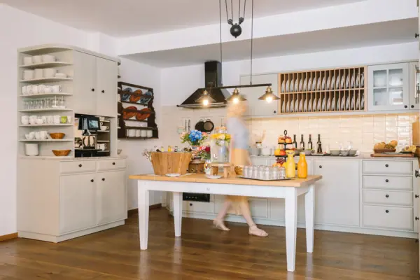 Een vrouw loopt een keuken binnen.