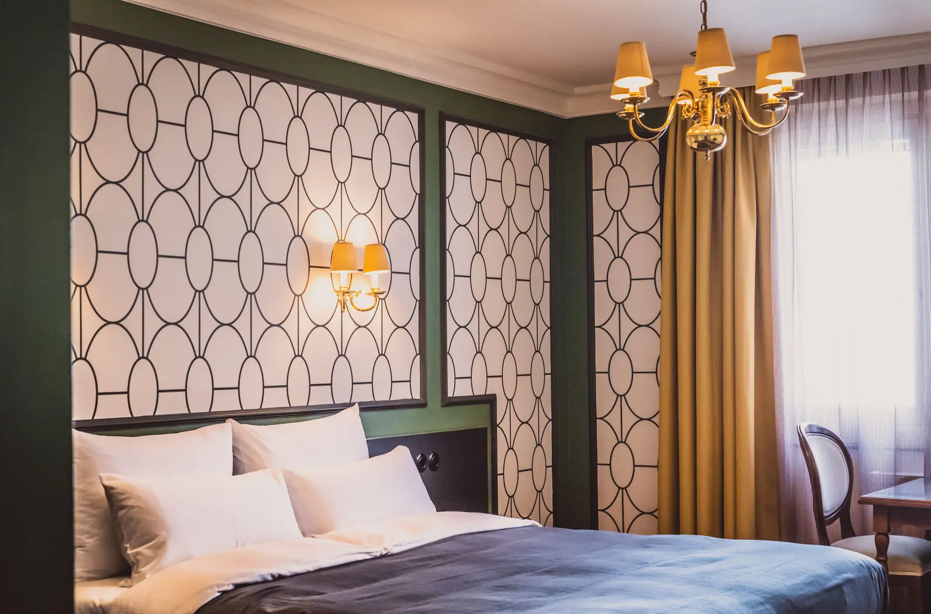 Kamer Een bed met een kroonluchter en gordijnen.