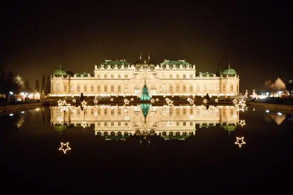 Kasteel Belvedere Een verlicht gebouw ’s nachts, met een weerspiegeling in het water.