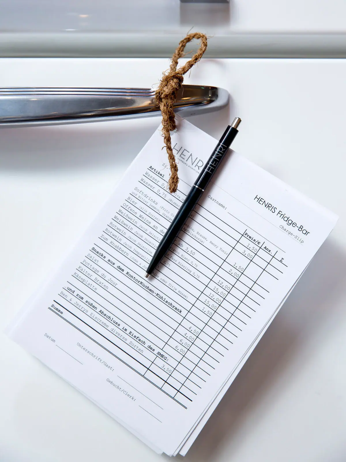 Een pen op een stuk papier hangt aan de deur van een koelkast.