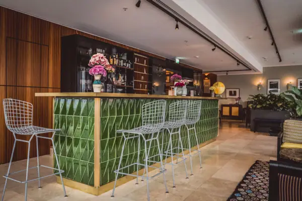 Een bar met stoelen en een tapijt ervoor.