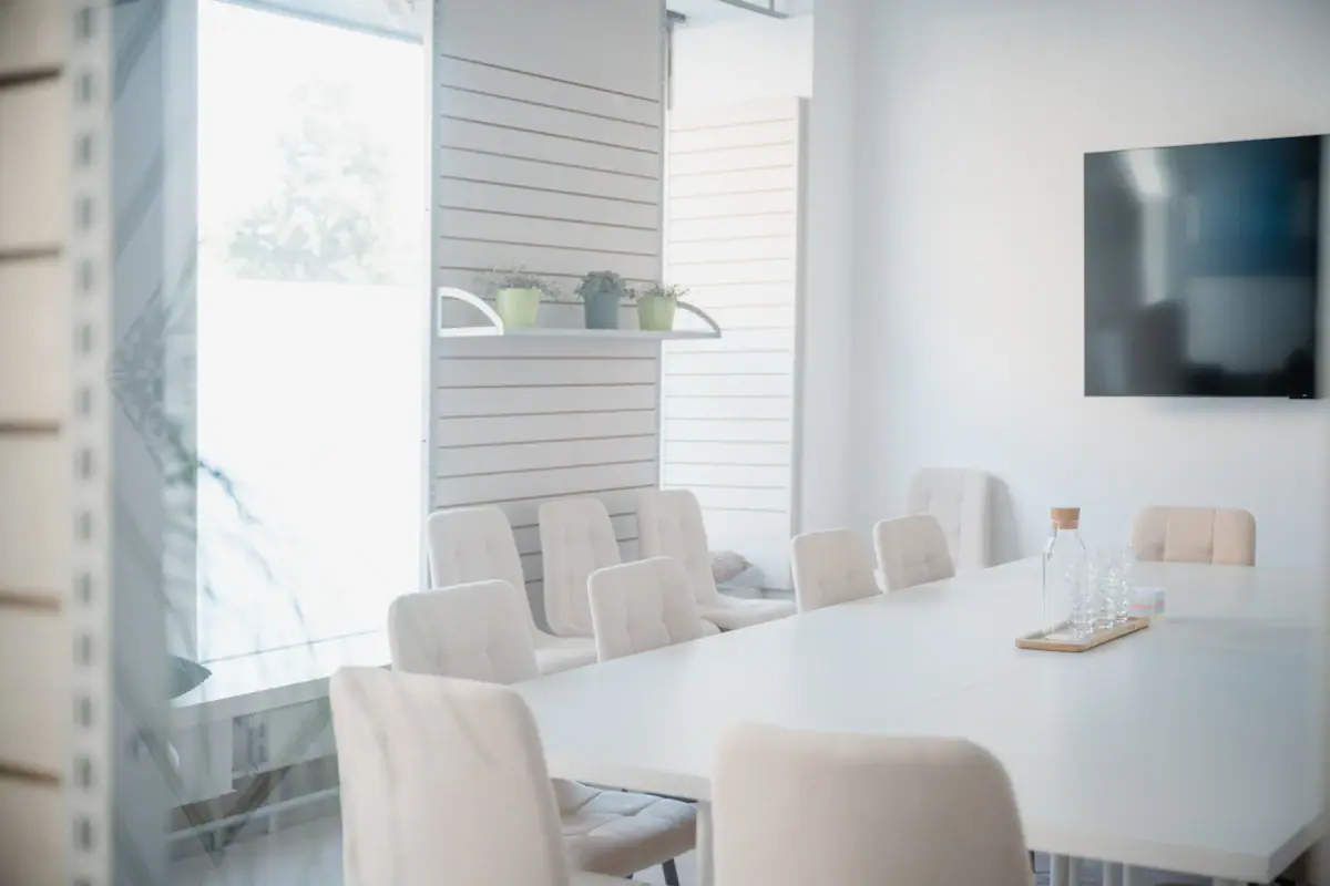 Een witte tafel met stoelen in een kamer.
