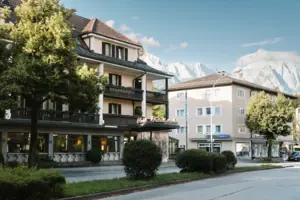 Buitenaanzicht van HENRI Hotel Garmisch-Partenkirchen met bomen en een weg.