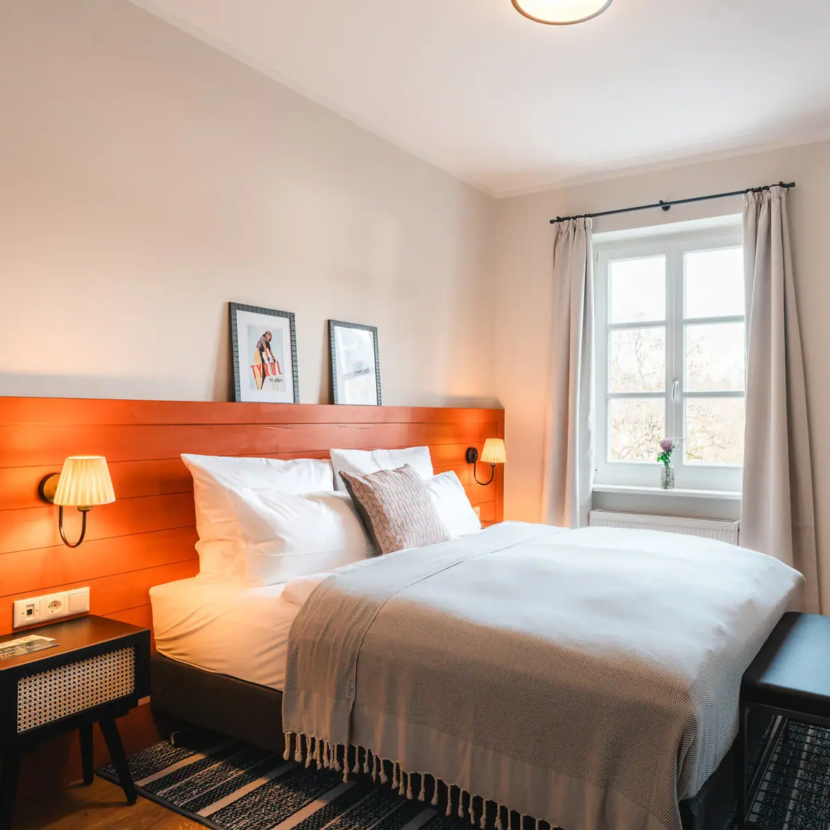 Bed Een bed met een houten hoofdeinde en een lamp.