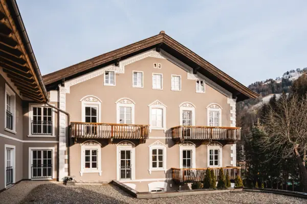 HENRI Kitzbühel buitenaanzicht Een gebouw met veel ramen en een oprit.