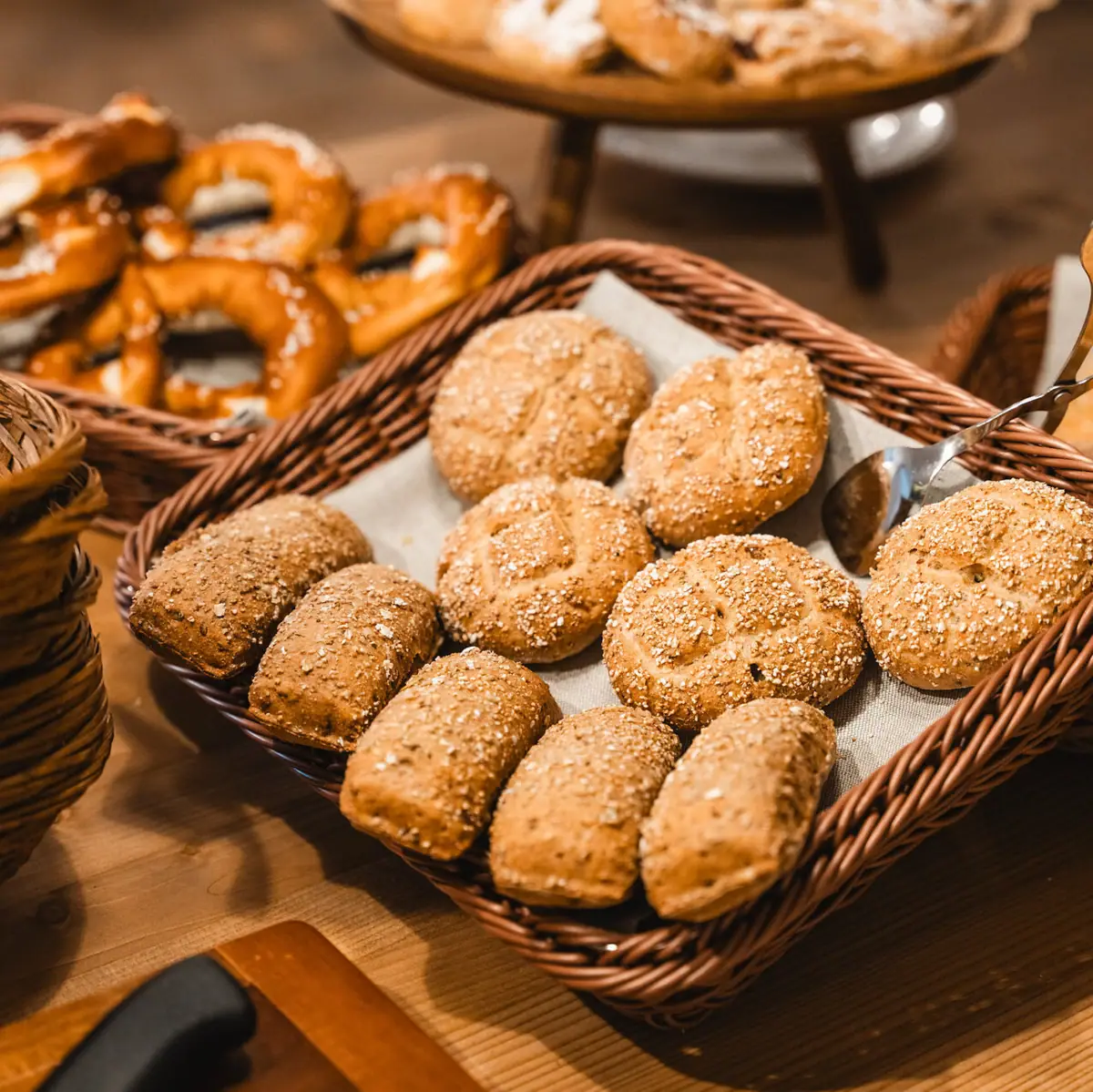 Ontbijt bij HENRI Verschillende mandjes brood en pretzels op een ontbijtbuffet.