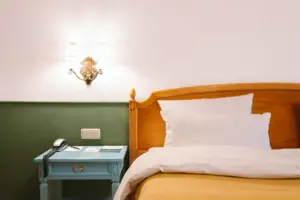 De hotelkamer Chambre in het HENRI Hotel Garmisch-Partenkirchen met een bed voor een groen-witte muur.