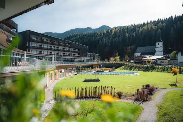 aja Bergresort Werfenweng Groen gazon met het aja Bergresort Werfenweng op de achtergrond.