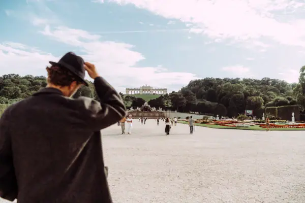 Wenen Schloss Schönbrunn Een man met een hoed kijkt over een pad dat leidt naar het Schönbrunn Paleis in Wenen.