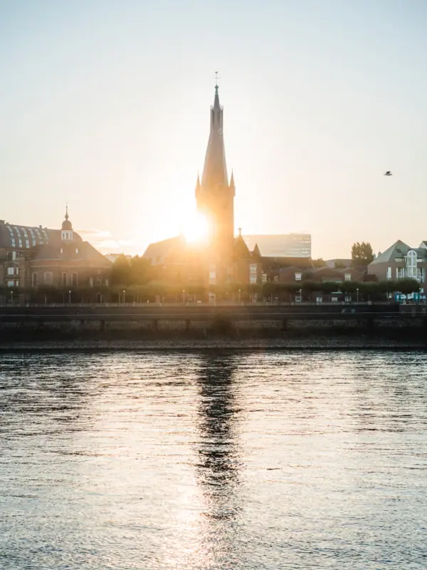 Gebouw met toren op de achtergrond tegen een heldere hemel.