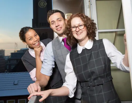 Een groep mensen staat voor een raam.