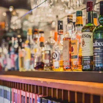 Een plank met flessen alcoholische dranken.