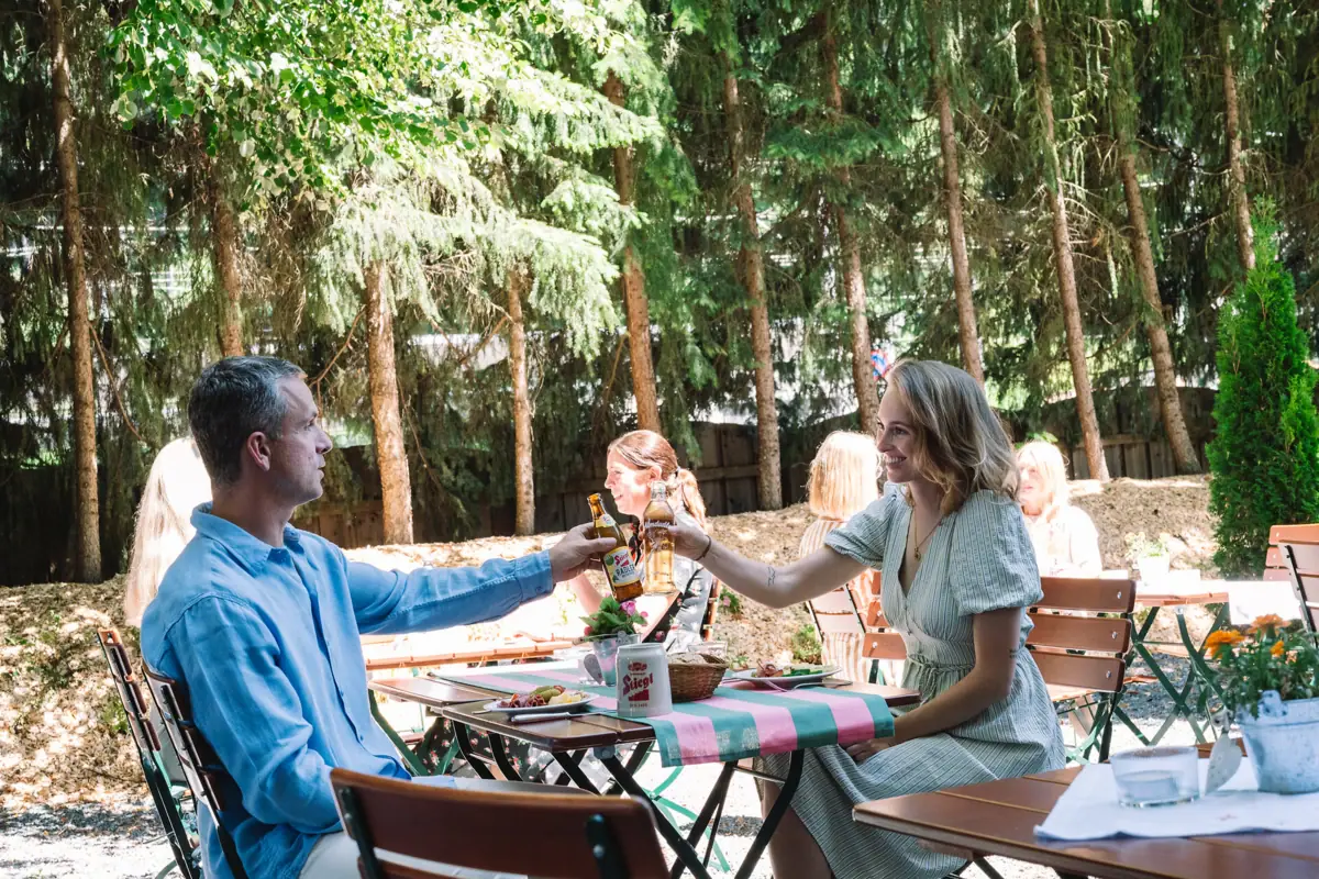 Een man en een vrouw zitten aan een tafel met drankjes.