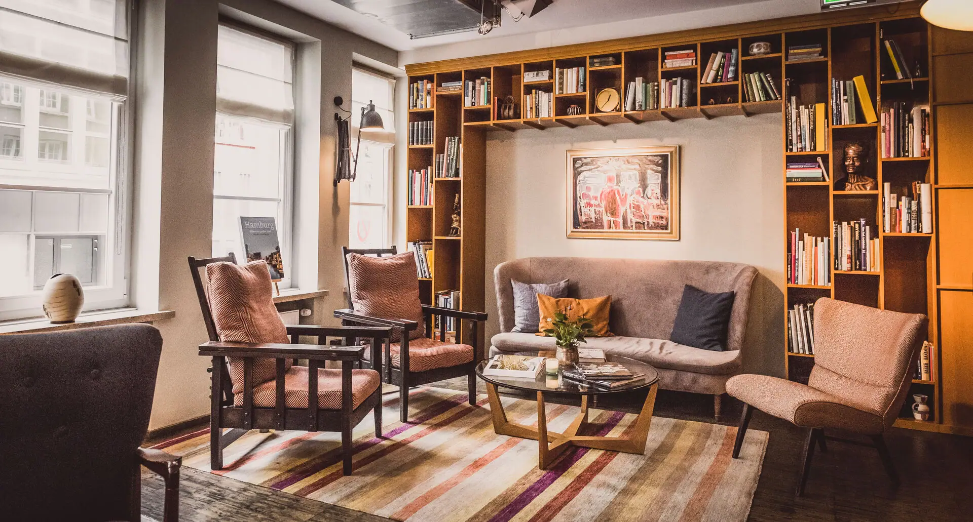 Zithoek met bank en fauteuils Loungeruimte bij HENRI Hamburg met een bank en stoelen.