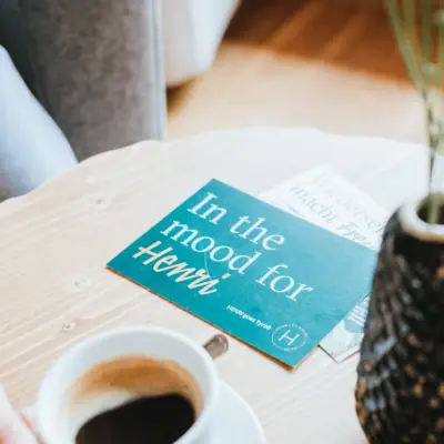 HENRI bon Een persoon houdt een kop koffie vast.