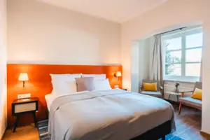 Bed Bed met witte hoes en oranje hoofdeinde