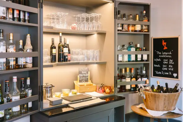 Een likeurkastje met flessen en glazen.