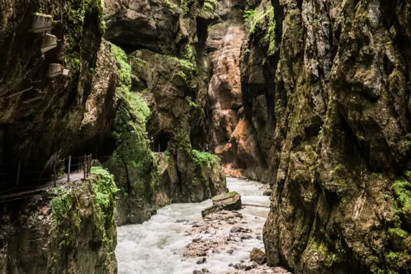 Tussen de rotsen van de Partnachklamm stroomt een rivier.