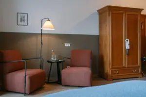 Zithoek in de Chambre met balkon in het HENRI in Garmisch-Partenkirchen Een kamer met een bed en stoelen.