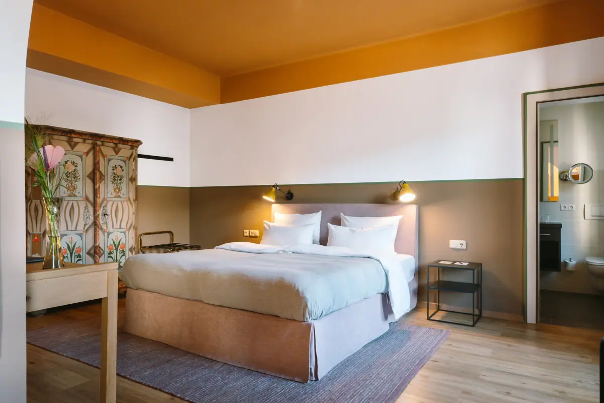 Een bed in een hotelkamer met een stijlvol interieur.