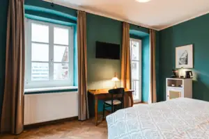 Kamer Een kamer met een bed en een bureau.