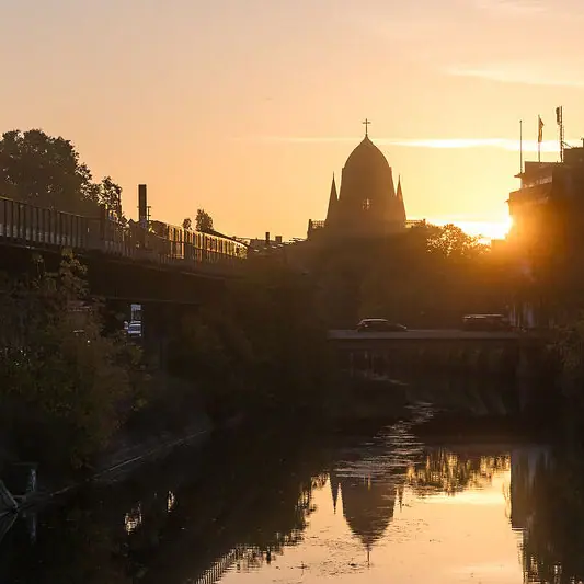 Spree in Berlijn in de avond Brug over een rivier met een gebouw op de achtergrond bij zonsondergang.