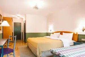 Een hotelkamer in het HENRI Hotel in Garmisch-Partenkirchen met een bed en een tafel.