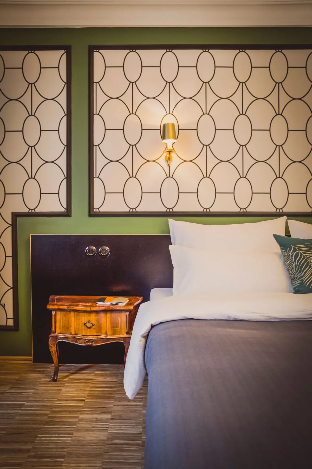Kamers in het HENRI Hotel Wenen Een bed met kussens en een nachtkastje.