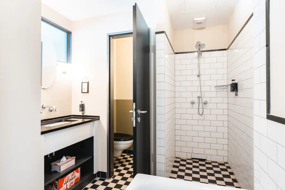 Een badkamer met wastafel en douche.