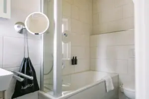 HENRI GAP Petit Kabinett Een badkamer met douche en bad.
